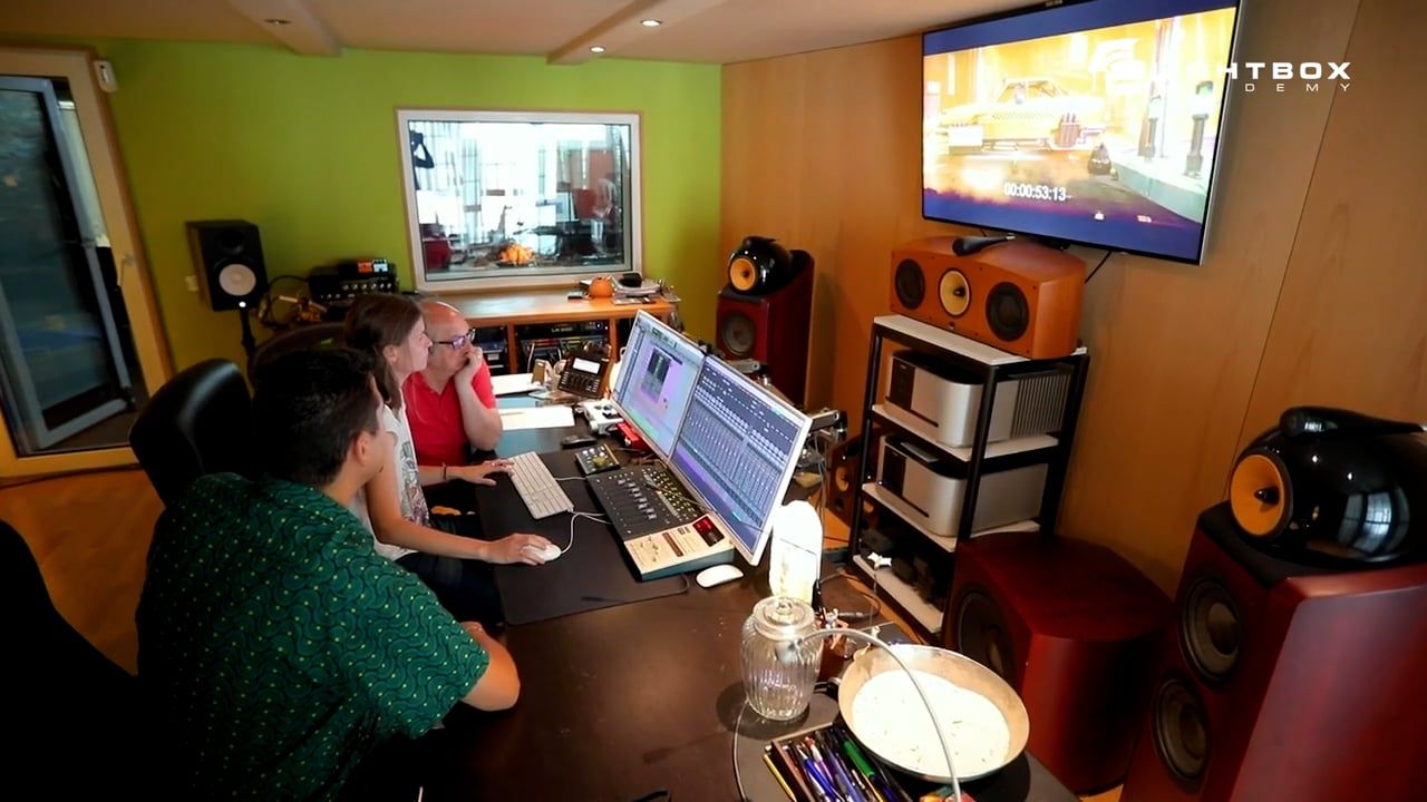 Dos profesionales trabajando en la postproducción de sonido frente a una pantalla que muestra una escena de “Madrid 2120” en estudio.